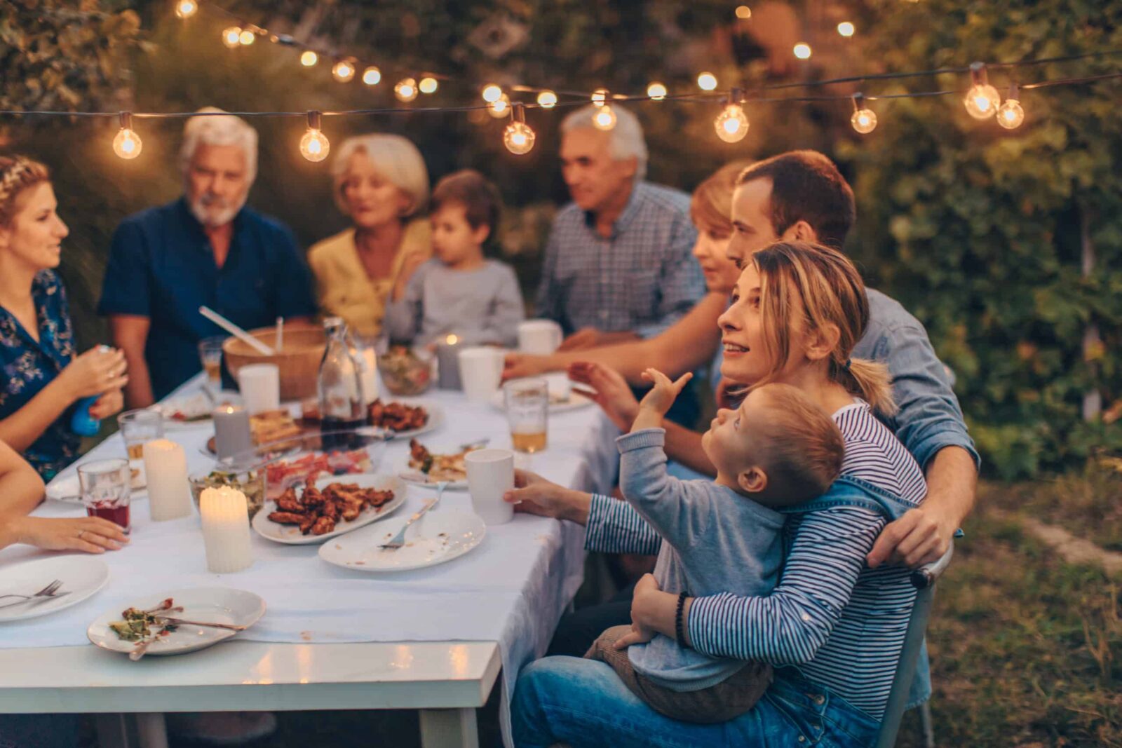 Foto einer großen Familie beim Thanksgiving-Essen, die den Feiertag gemeinsam im Hinterhof feiert