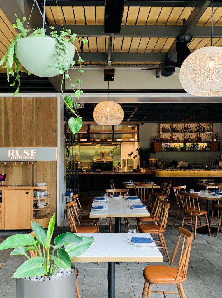 Leeres Restaurant und Bar mit stilvoller Beleuchtung, Topfpflanzen und elektrischen Heizkörpern