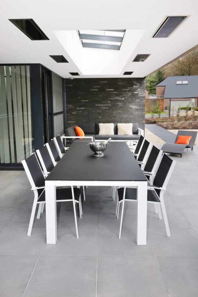 Schwarzer Acht-Sitzer-Tisch im Außenbereich mit Dach und flacher Heizung im Dach